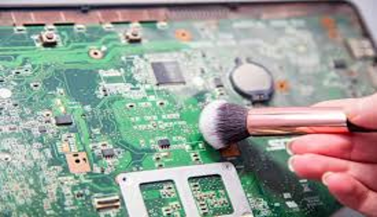 une carte mère qui ce fait nettoyer par un petit pinceaux